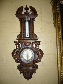 A Highly Carved French Walnut Barometer Features Winged Griffins