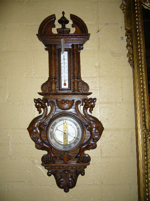 A Highly Carved French Walnut Barometer Features Winged Griffins