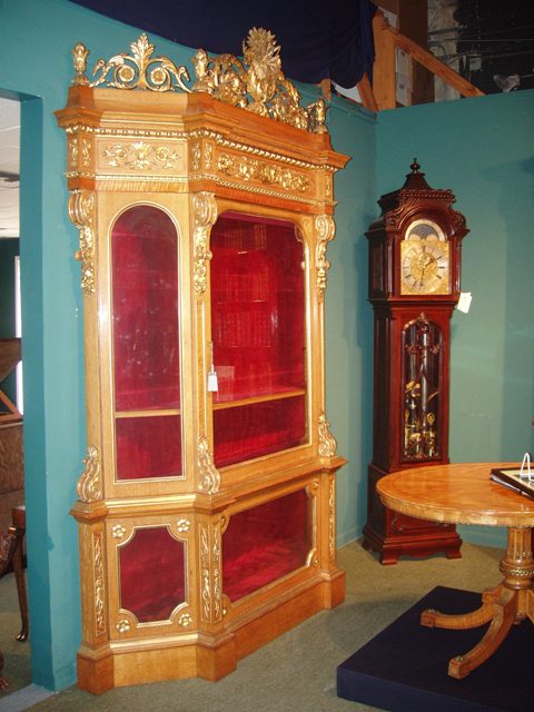 A Museum Quality Oak Display Cabinet with fine quality Giltwood Carving to the Crown and Body of the cabinet.