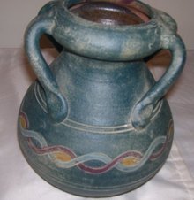 A Large green pottery vase with 4 applied handles, hand turned clay vase