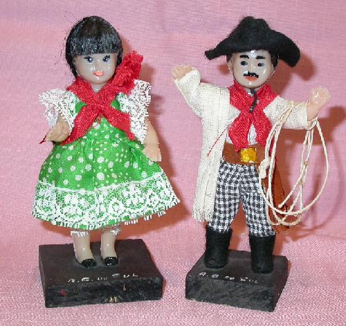 PAIR OF LATIN LOOKING DOLLS ON WOOD STANDS