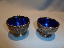 F.B. ROGERS PAIR OF SILVER PLATE ORNATE SALTS WITH COBALT LINERS