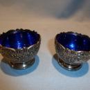 F.B. ROGERS PAIR OF SILVER PLATE ORNATE SALTS WITH COBALT LINERS