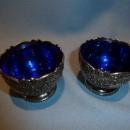 F.B. ROGERS PAIR OF SILVER PLATE ORNATE SALTS WITH COBALT LINERS