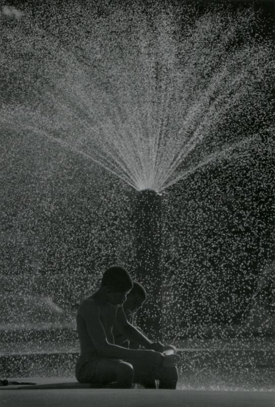 African American kids in sprinkler spray