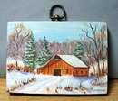 Old barn scene in snow painted on piece of board.
