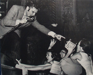 Picture of Elvis With Mike and Pointing to Fan 1956
