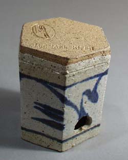 Stoneware candle holder with punched out star shapes