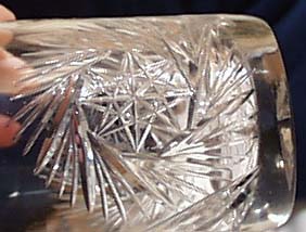 Cut glass tumbler with starburst design.