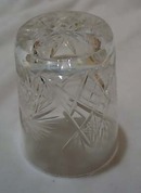Cut glass tumbler with starburst design.