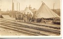 WWI postcard men in front of barracks/train