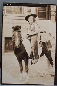 Old photo of young girl on pony with costume