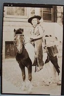 Old photo of young girl on pony with costume