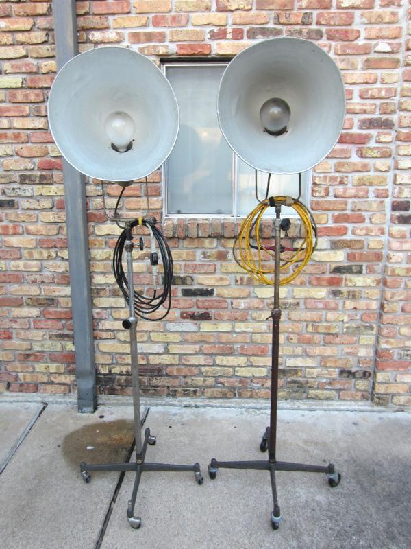 VERY RARE! PAIR OF VINTAGE PHOTOGENIC MACHINE CO. INDUSTRIAL MACHINE AGE STEAM PUNK MID-CENTURY MODERN ADJUSTABLE FLOOR LAMPS FLOODLIGHTS MODEL LIGHT ON IRON WHEEL BASE CASTERS