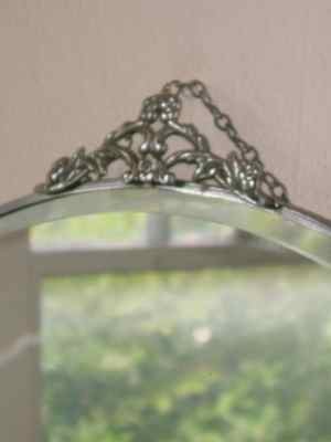 Beveled Oval Mirror with Floral & Leaf Chrome Crest