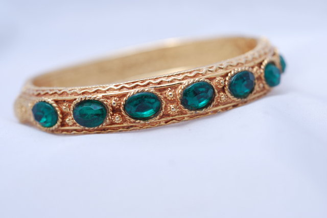 Lovely green glass stone/gold tone hinged bangle bracelet.