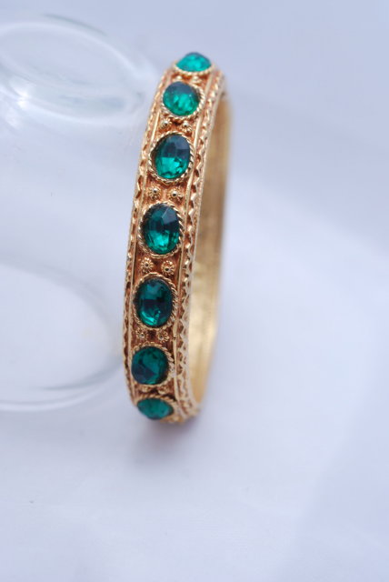 Lovely green glass stone/gold tone hinged bangle bracelet.
