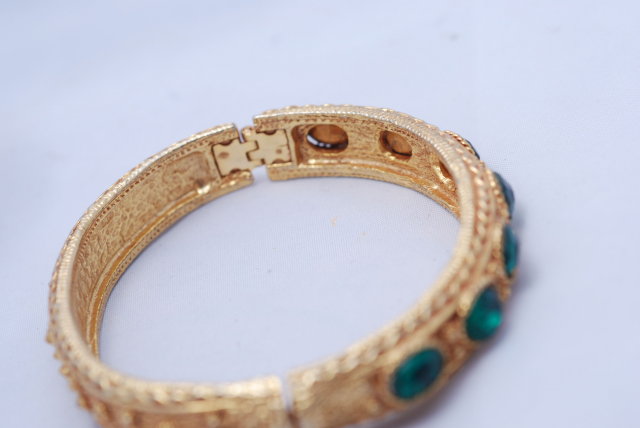 Lovely green glass stone/gold tone hinged bangle bracelet.